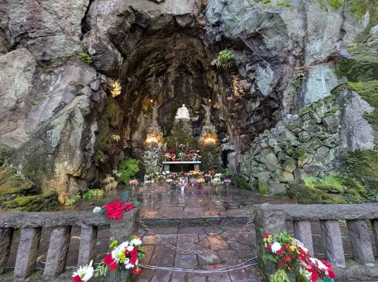 The cave shrine at The Grotto with floral arrangements