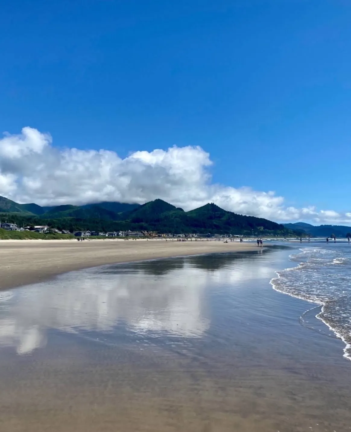 The wide flat shoreline of Cannon Beach with the Coast Range behind
