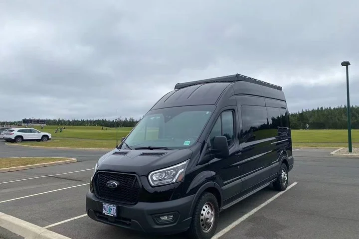 Black Ford Transit high-roof passenger van